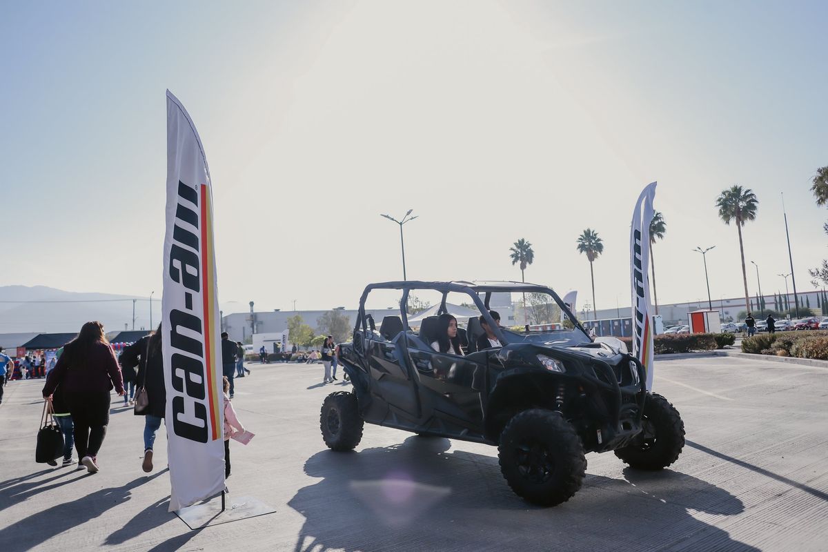 Can-Am vehicle on display next to brand flags at the BRP family day