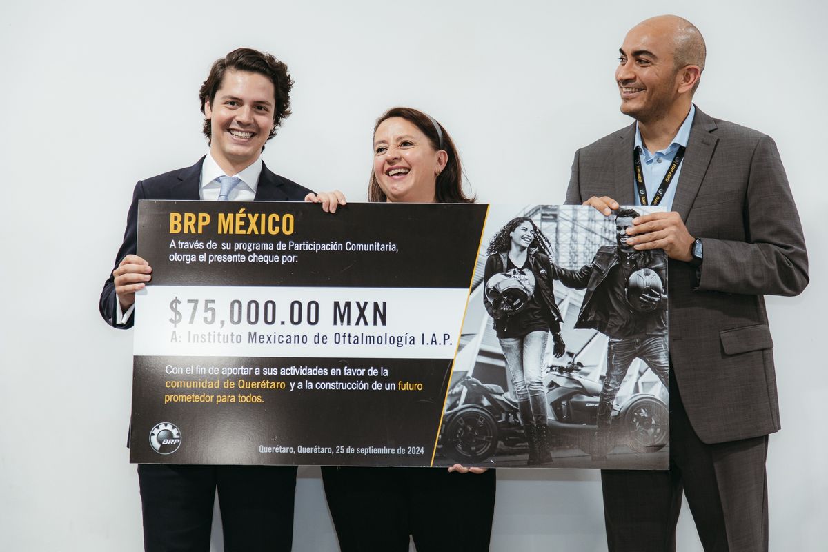 Three people holding a giant BRP México cheque for 75,000 pesos to the Mexican Institute of Ophthalmology