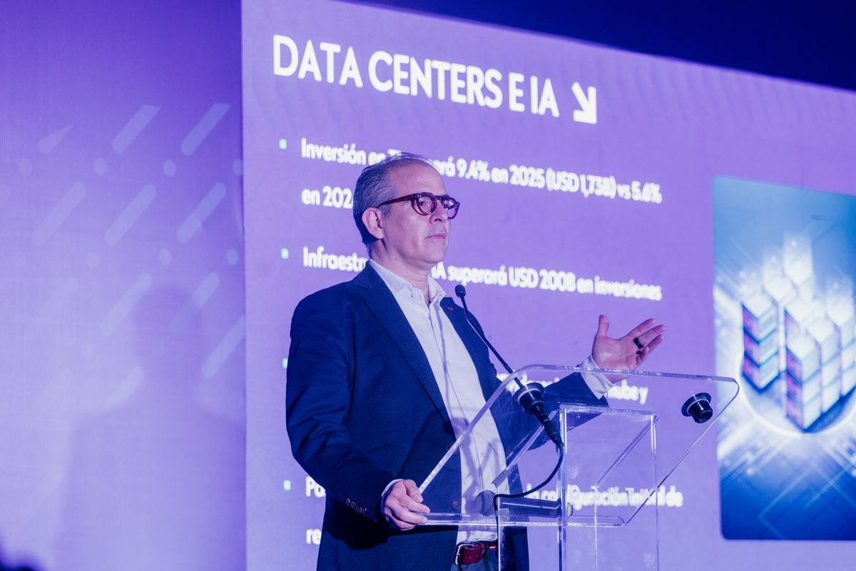 Speaker at an acrylic lectern in front of a screen showing the “Data centers and AI” presentation during the inauguration of ODATA’s QR04 data center